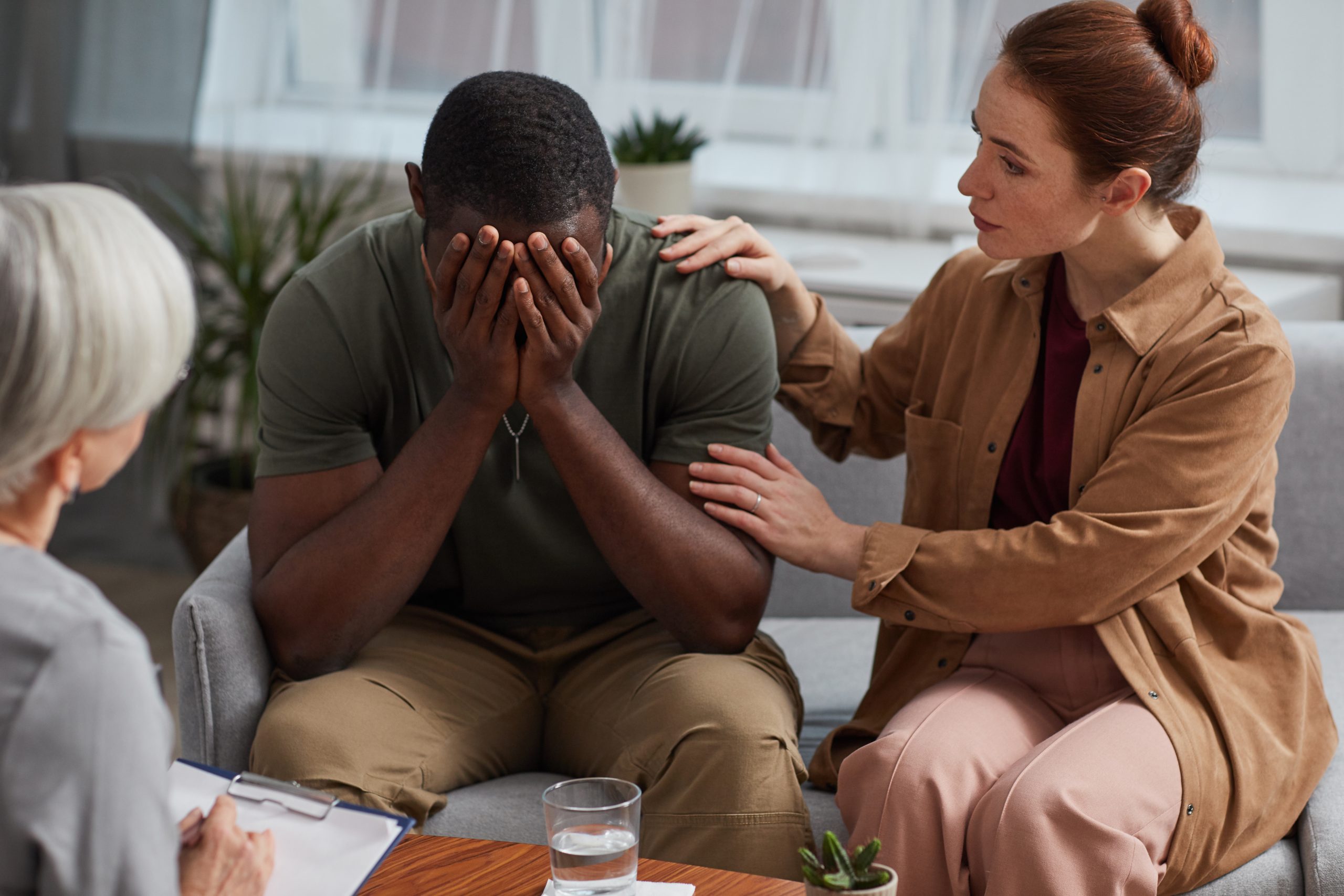 A compassionate therapist providing mental health counselling in Louisville KY to a smiling female client in a cozy office setting.